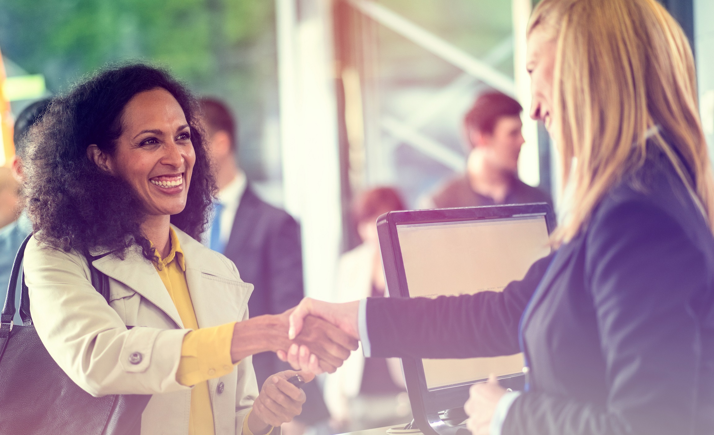Happy looking woman shaking hands with a credit union teller